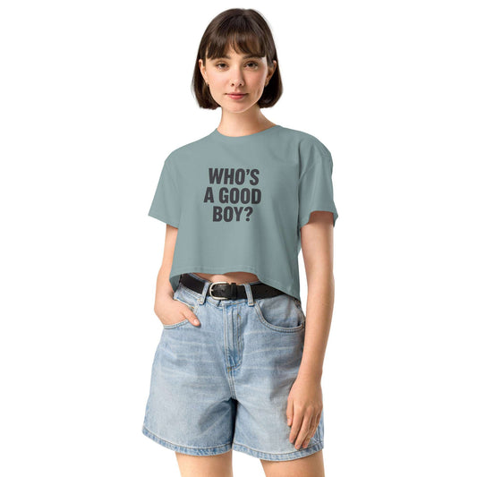 Person wearing a light blue t-shirt with 'WHO'S A GOOD BOY?' text and denim shorts on a white background
