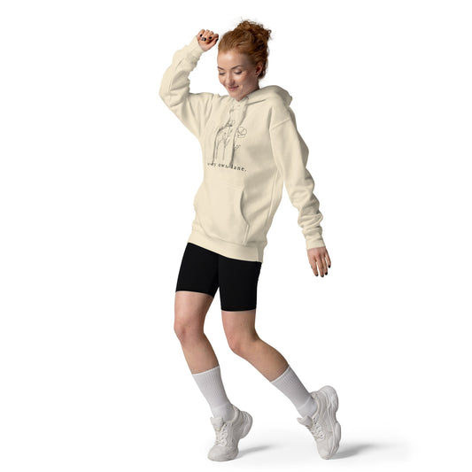 Woman wearing a beige hoodie, black shorts, and white sneakers on a white background