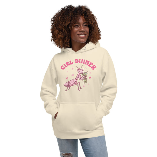 Woman wearing a beige hoodie with 'Girl Dinner' graphic design on a white background