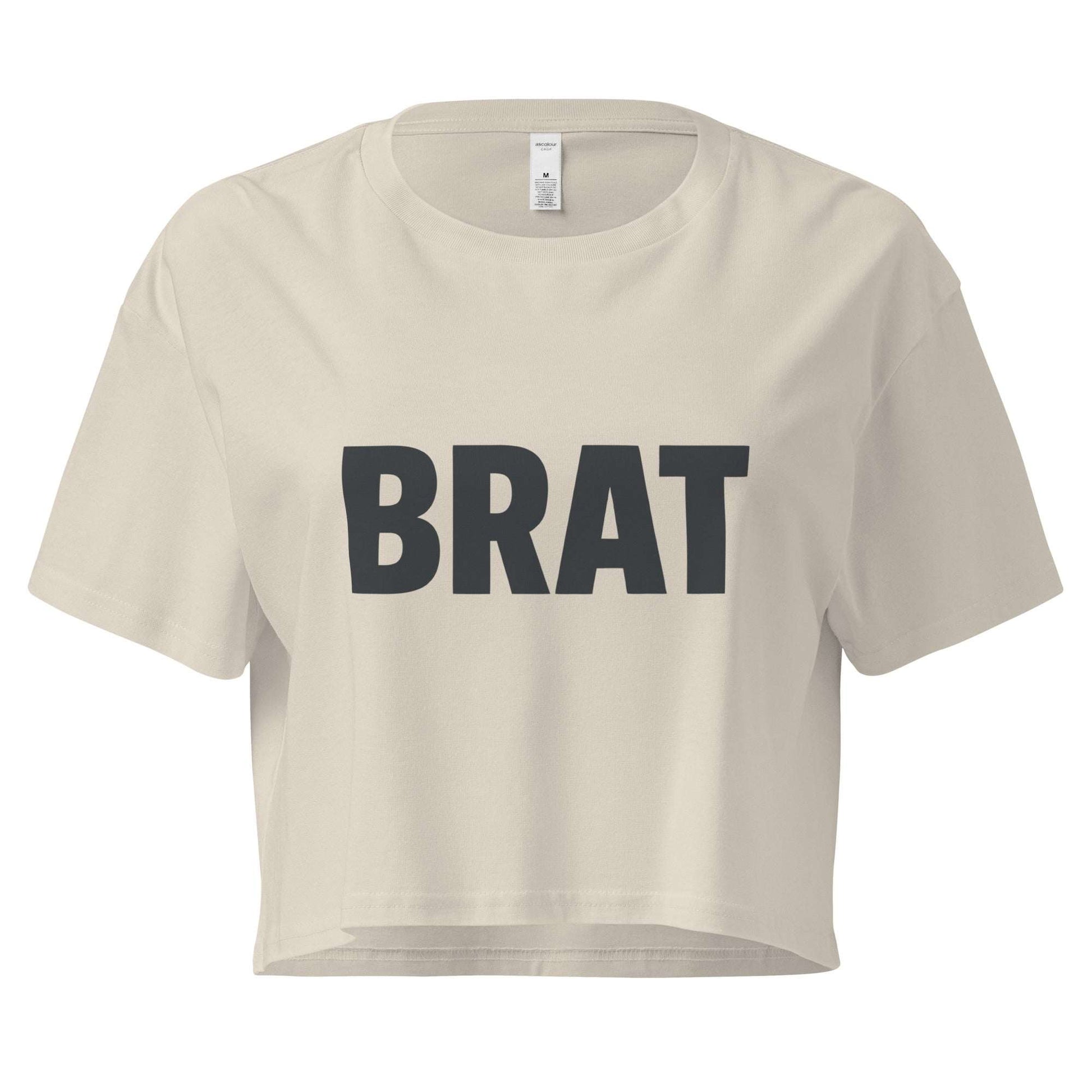 Beige crop top with 'BRAT' text on a white background
