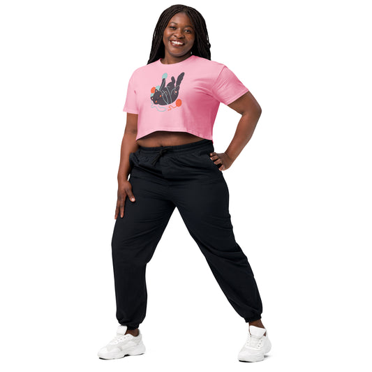 Woman wearing a pink crop top and black pants on a white background
