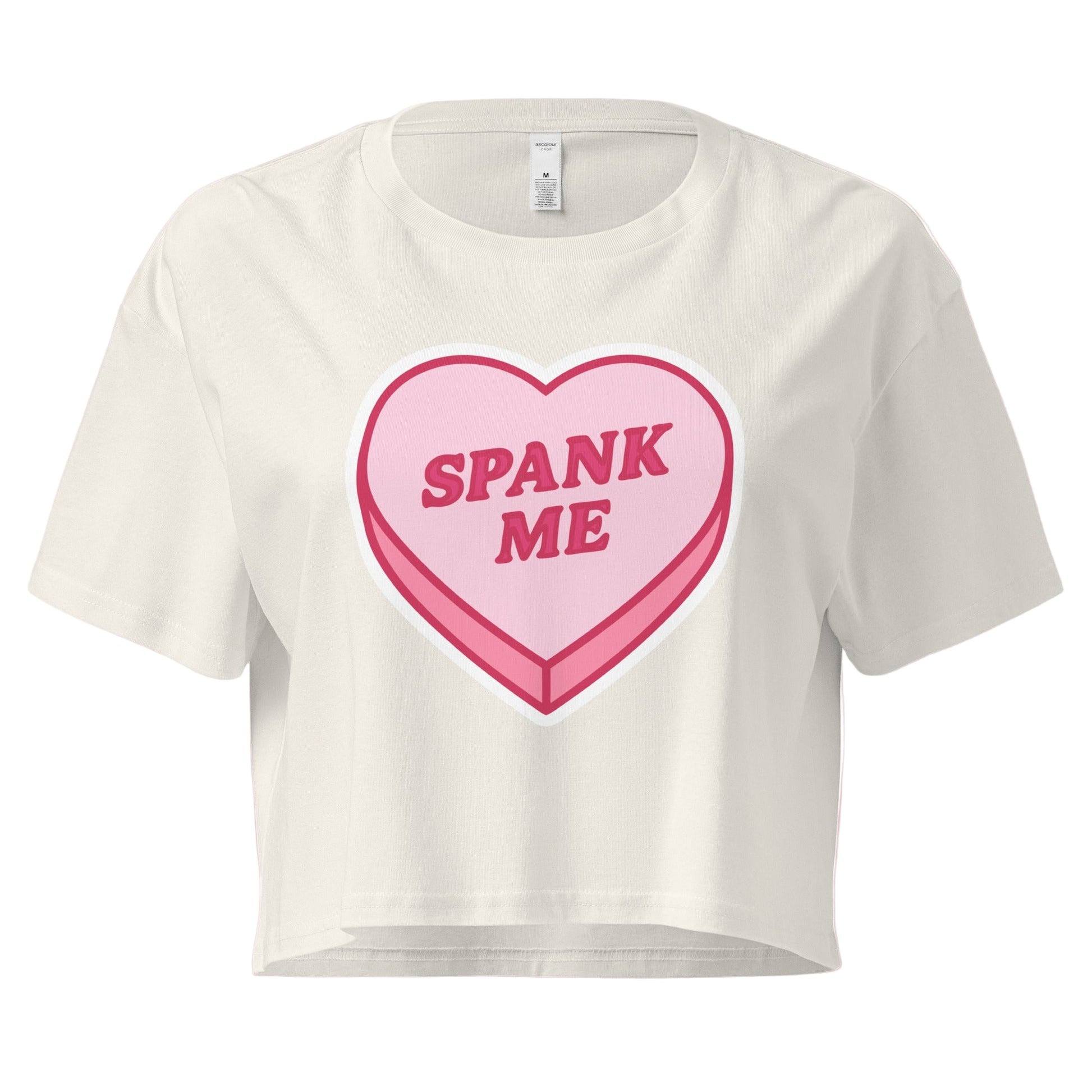 White t-shirt with a pink heart-shaped candy design and 'SPANK ME' text on a white background