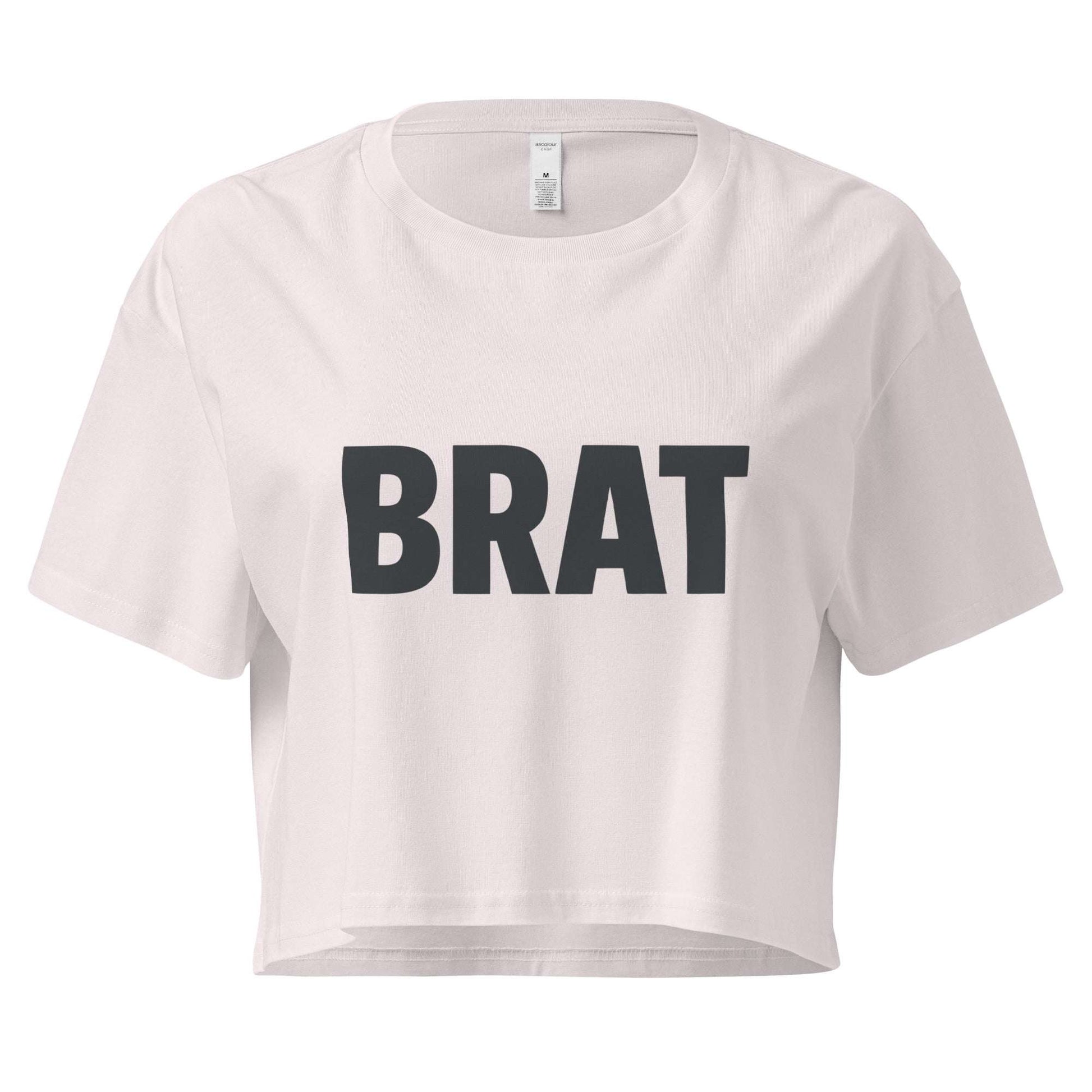 White crop top with 'BRAT' printed in black on a white background