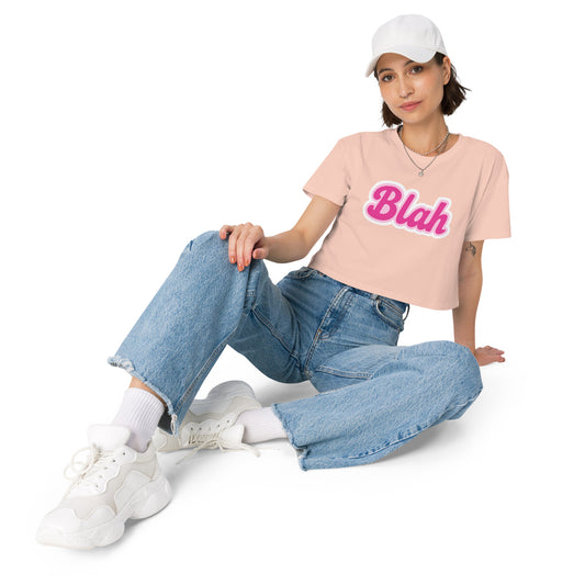 Person wearing a pink t-shirt with text, blue jeans, and white sneakers on a white background