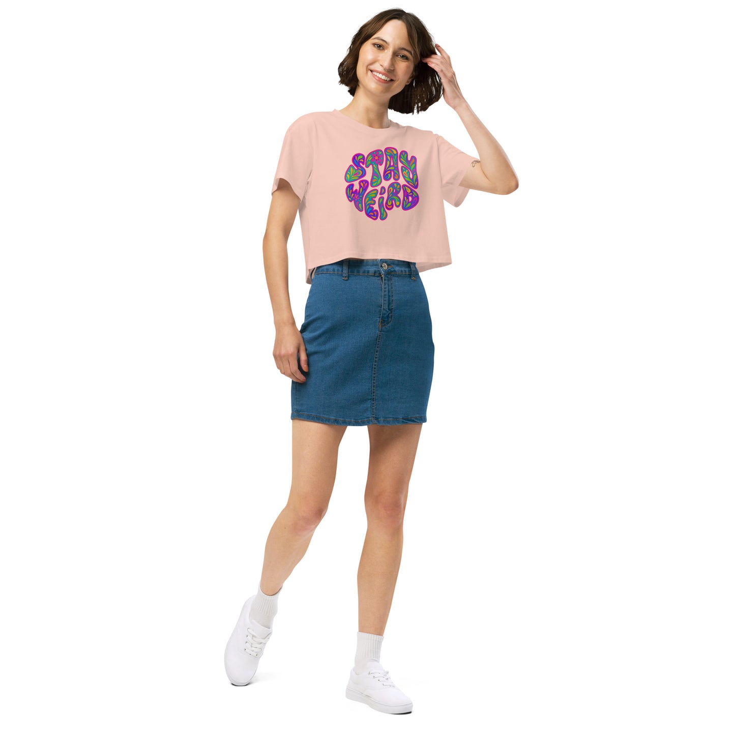 Woman wearing a pink t-shirt with colorful text and a blue skirt on a white background