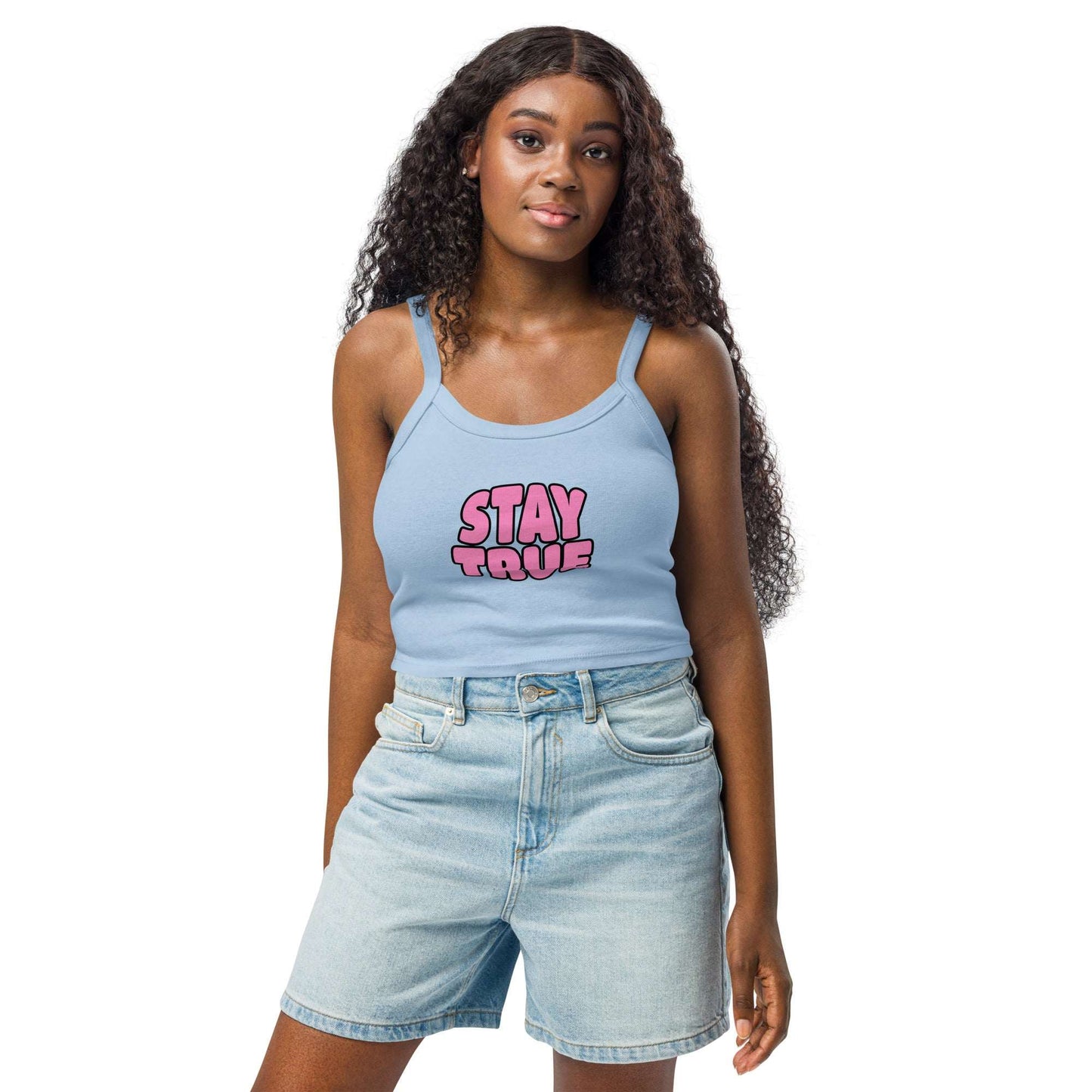Woman wearing a light blue tank top with text and denim shorts on a white background